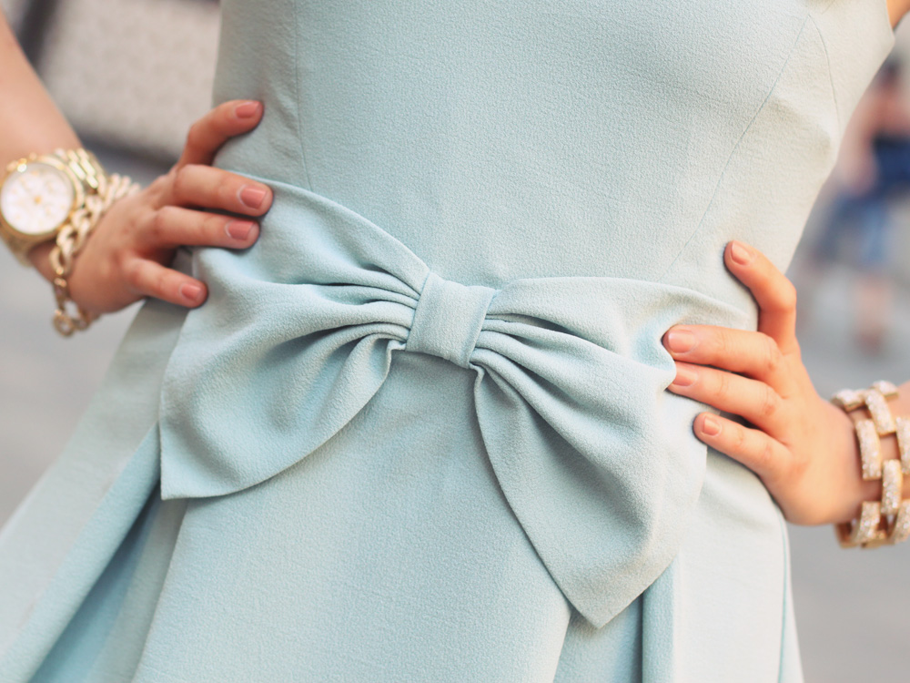 Skirt The Rules Blog; NYC fashion blogger; style blog; feminine outfit photos; Hello Glam Prim and Proper blue bow dress; Banana Republic sparkle stone white statement necklace; Linea Pelle Grayson Bar Clutch in blus; J.Crew pave square link bracelet; Michael Kors gold boyfriend watch; Brighthouse Baubles gold chain bracelet; Pour La Victoire Mai wedge pump