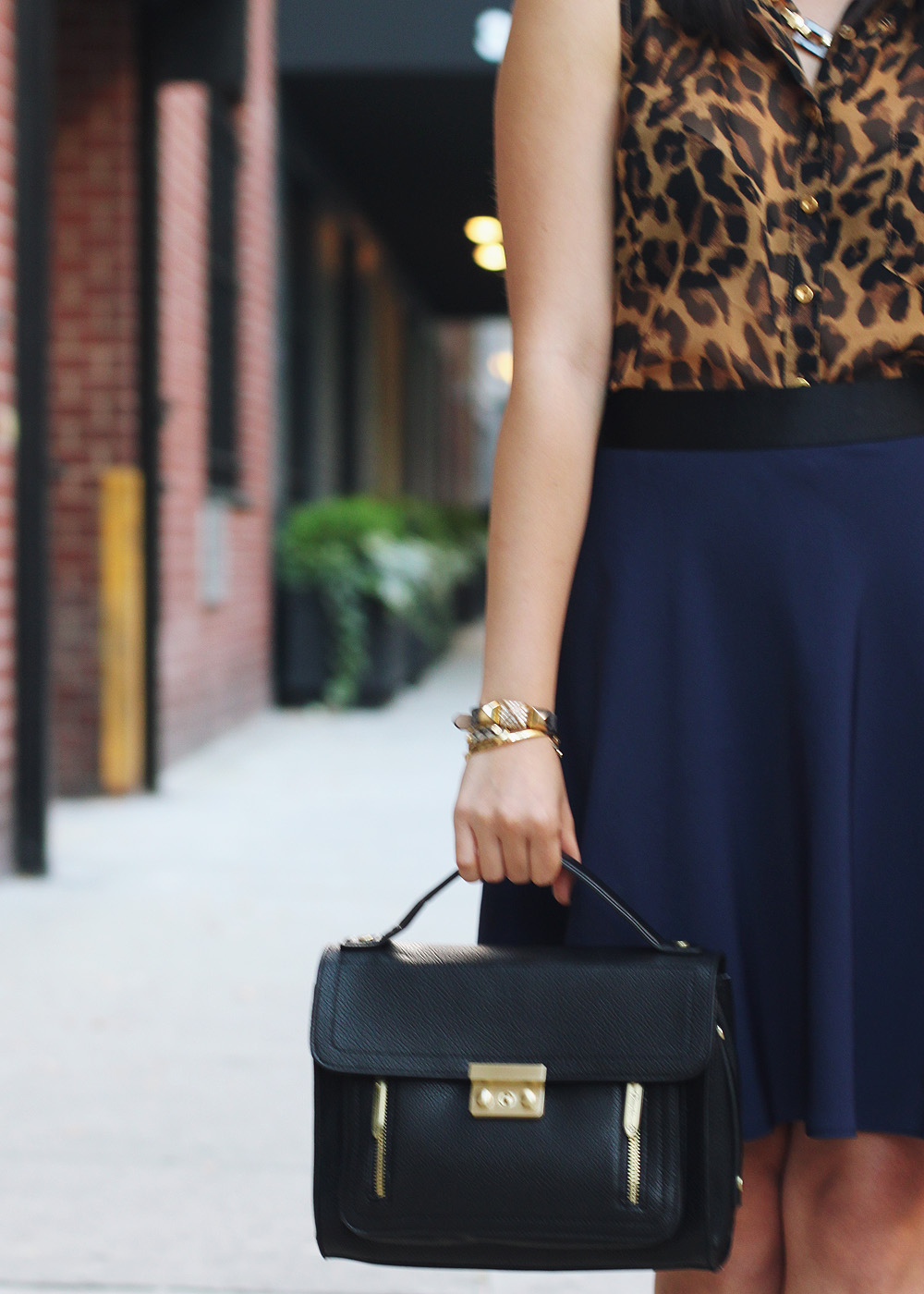 Skirt The Rules Blog; NYC fashion blogger; style blog; fall outfit photo; leopard sleeveless blouse; 3.1 Phillip Lim x Target navy skirt; 3.1 Phillip Lim black satchel; C. Wonder tortoise link necklace; C. Wonder snakeskin skinny bangle; Gorjana & Griffin alphabet disc bracelet; Juicy Couture pave pyramid bracelet; Pour La Victoire Mai patent black wedge pumps